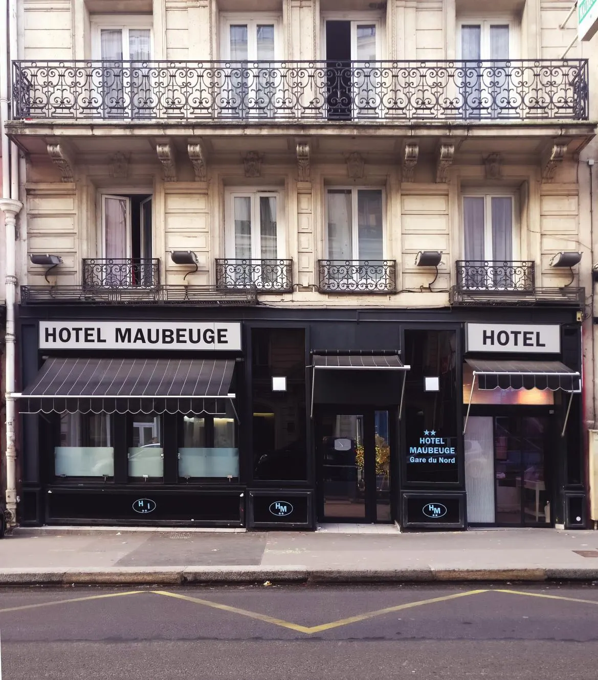 Devanture de l'hôtel : façade haussmannienne, store et enseigne sur rue
