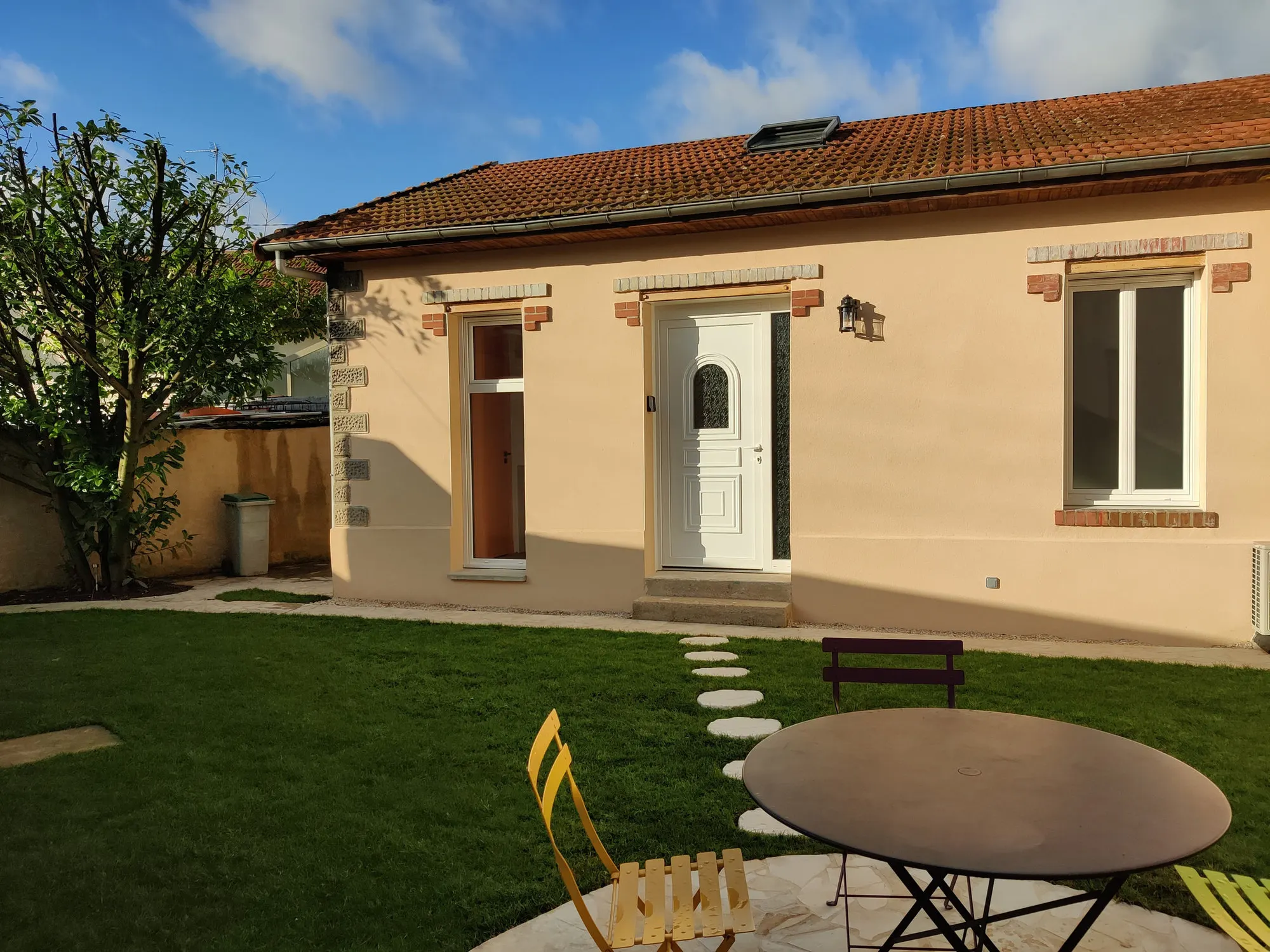 Façade sur jardin après travaux, enduit clair et terrasse aménagée