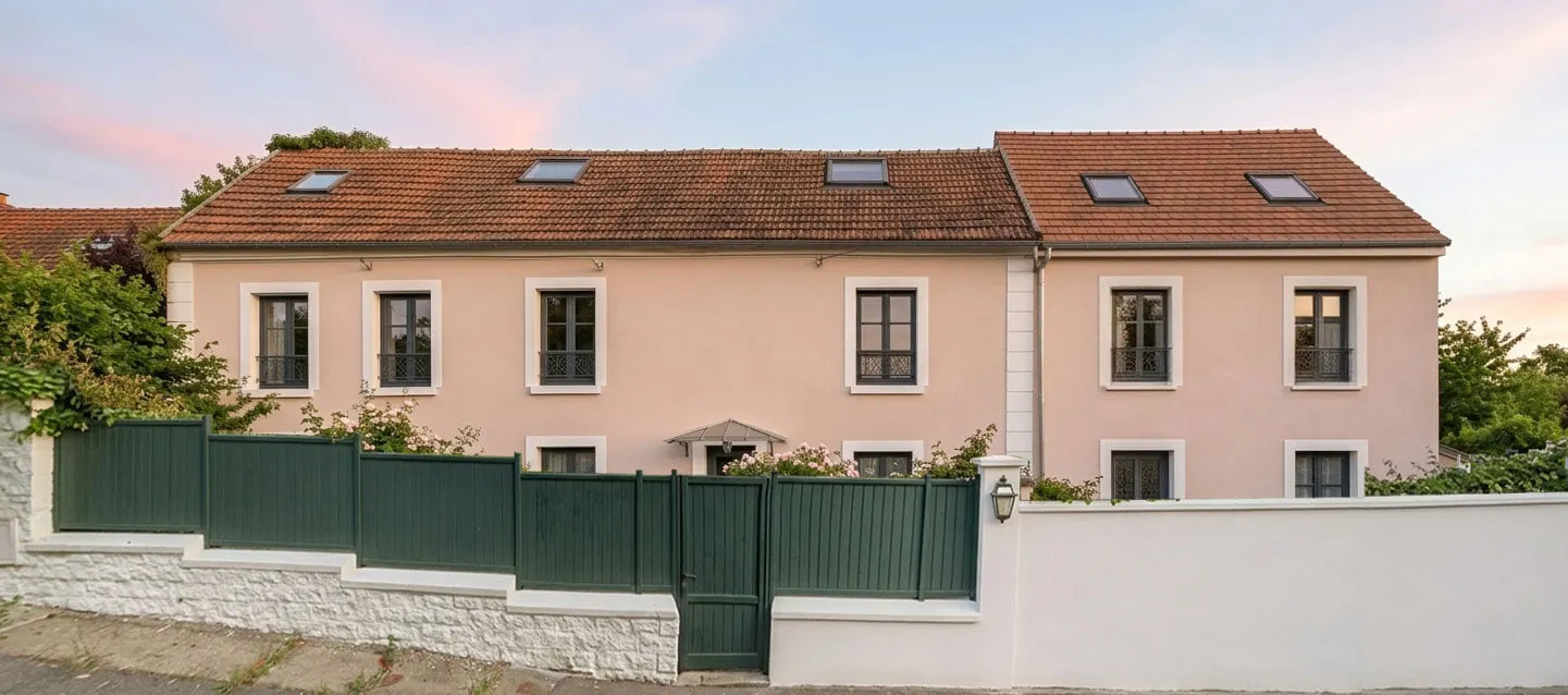 Insertion du projet : façade sur rue en enduit rose beige, clôture verte et toiture en tuiles