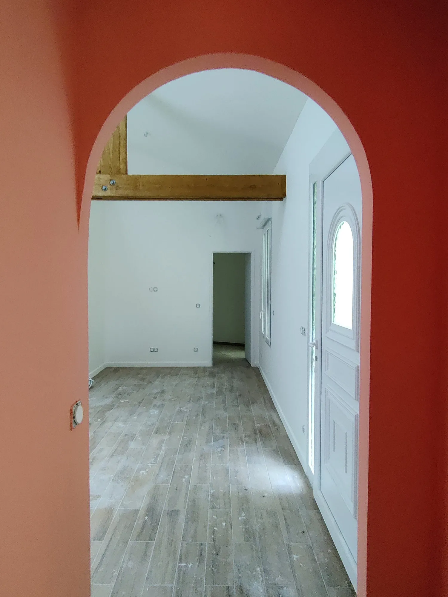 Couloir traversant sous arche maçonnée dans une maison rénovée à Aulnay-sous-Bois